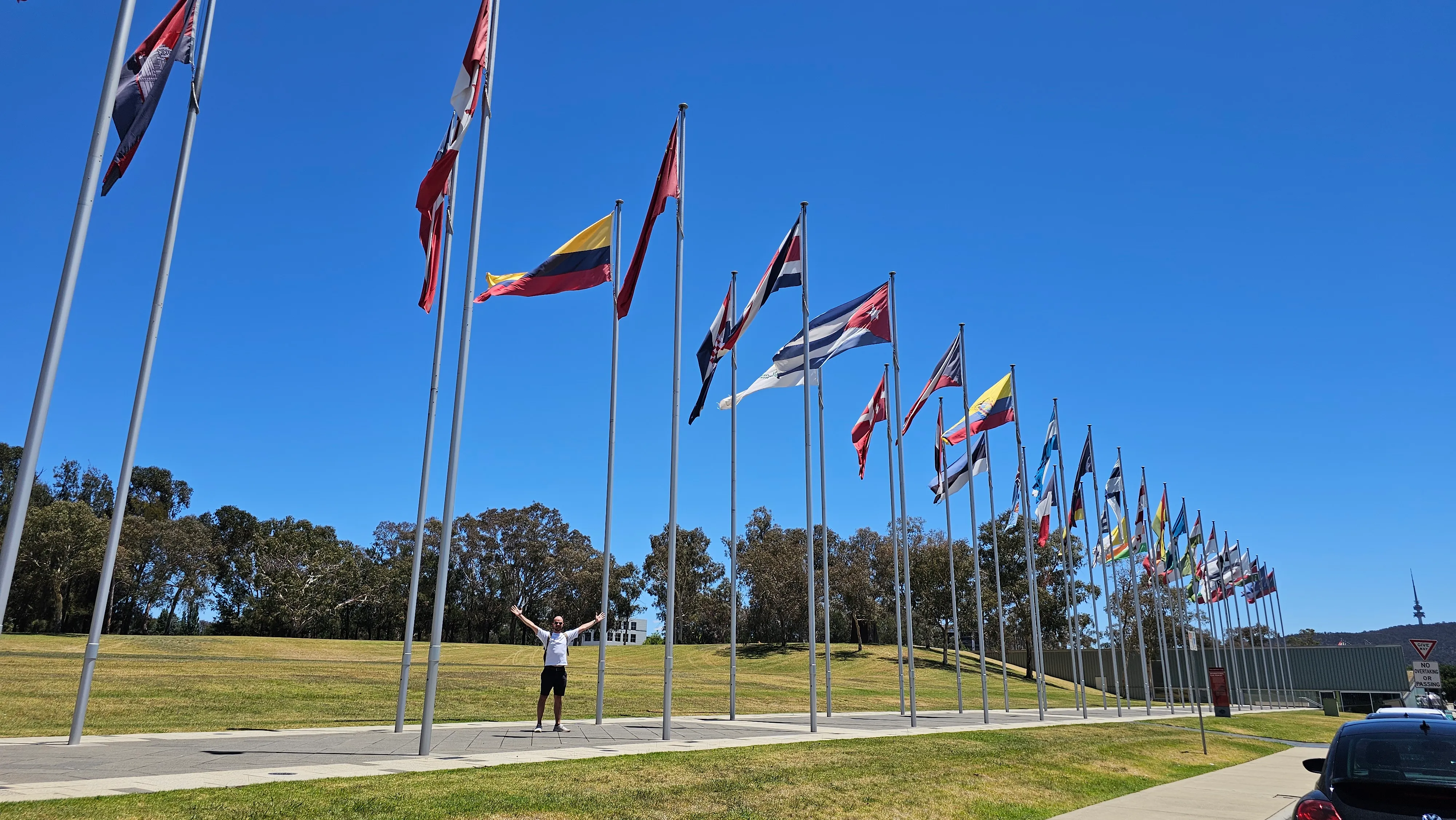 Me standing in front of the International Flag Display, as seen on Season 10 of Jet Lag: The Game!