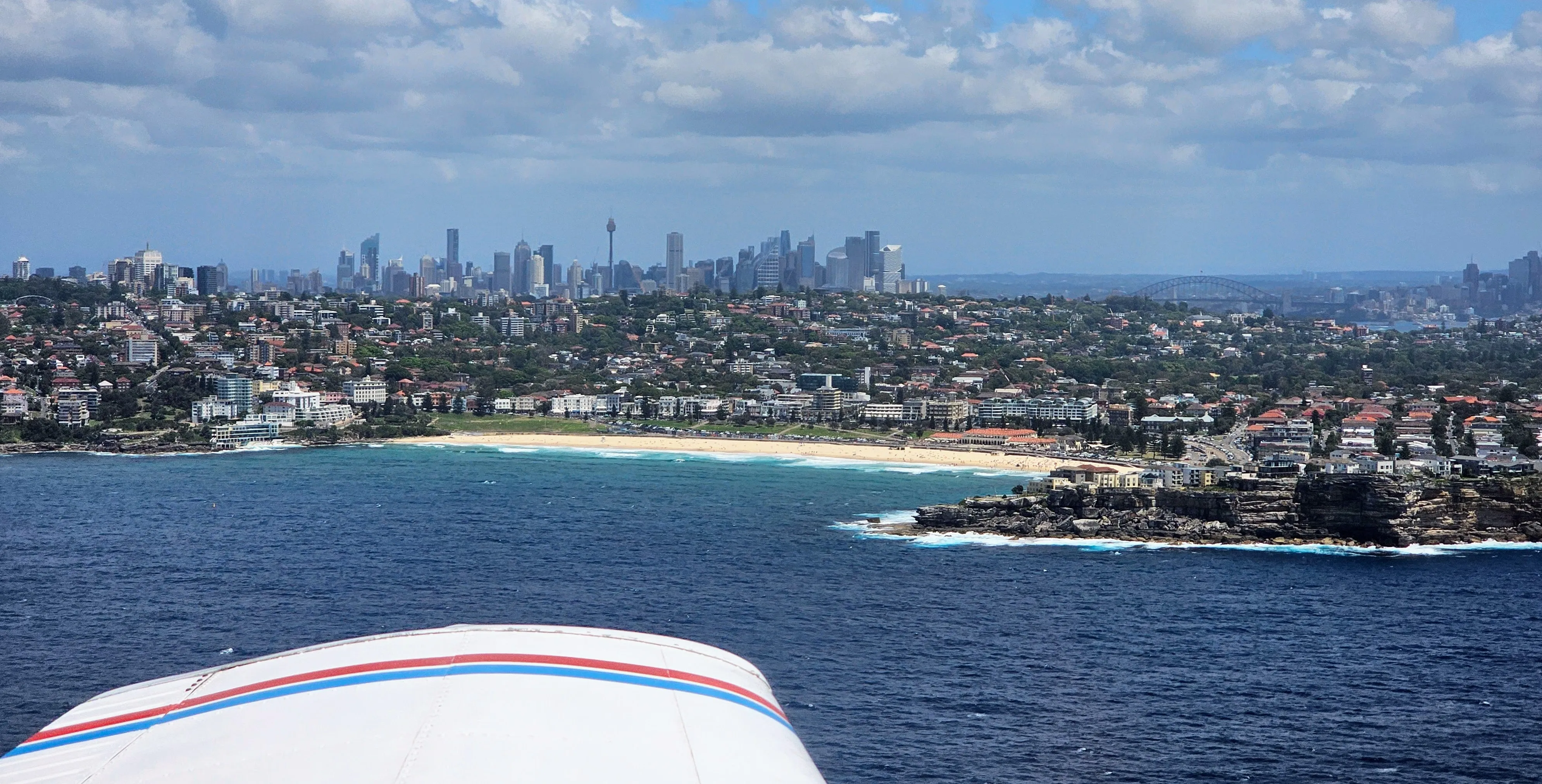 Bondi Beach, with the Sydney skyline in the background. Taken from a PA-28 flying at 500ft about 2 miles offshore.